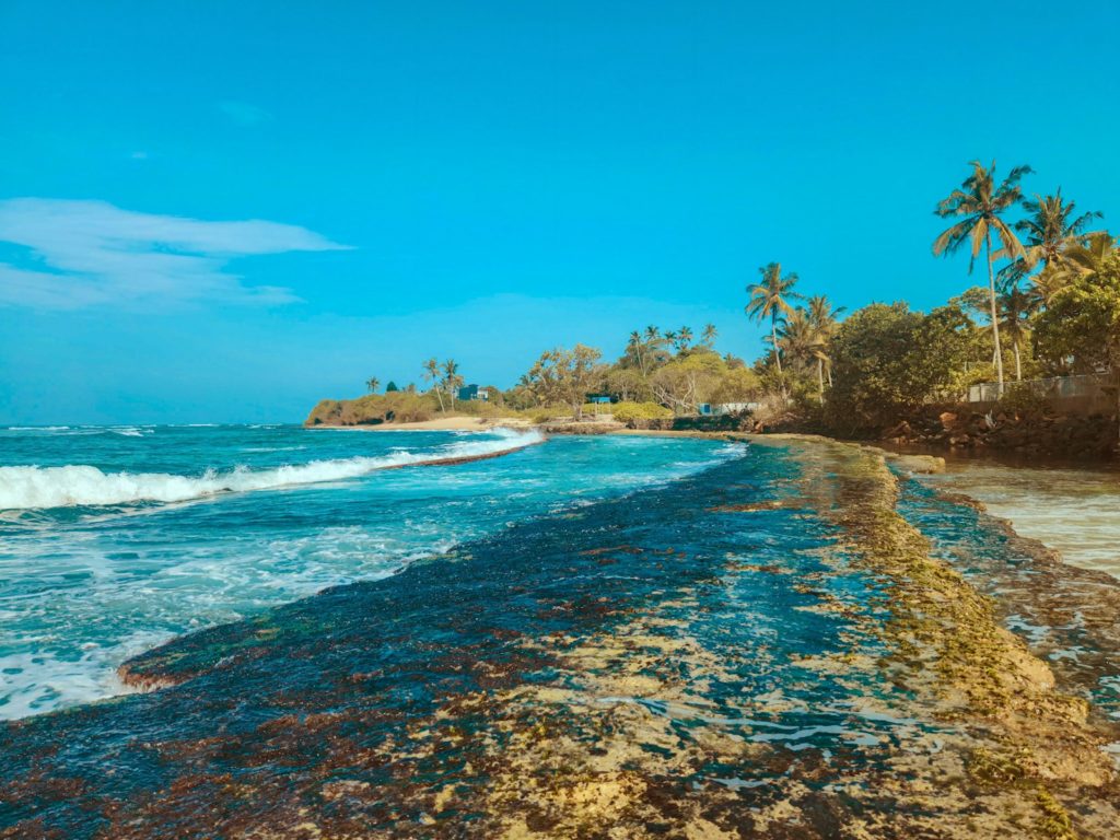 Una playa de arena con olas que llegan del océano